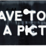 Long horizontal painting of white letters on a black background. The letters spell out the sentence, do I have to hraw you a picture?