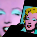 a mobile phone with an image of Warhol's painting of Marilyn Monroe