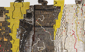 A detail of a tapestry made of bottle caps and metal scraps.