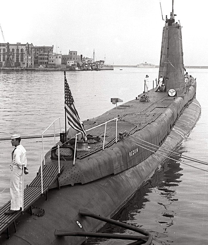 a vintage photo of a submarine docked in italy.