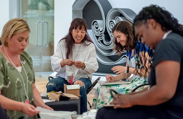 A group of female teachers sitting in a circle, talking and laughing.