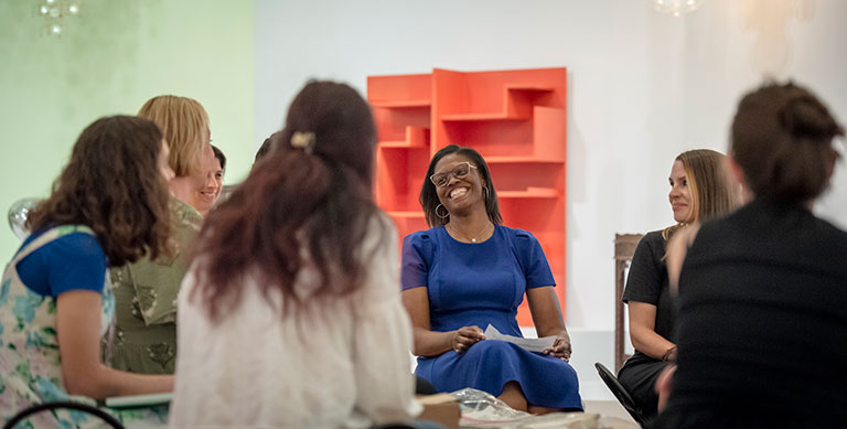 A group of female teachers sitting in a circle, talking and laughing.