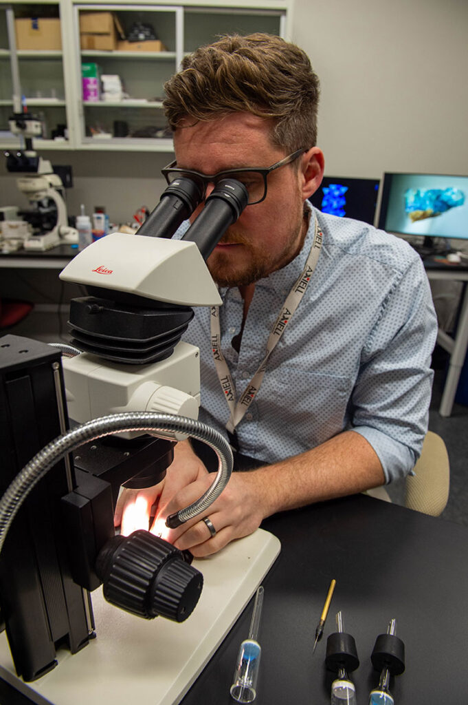 A man looking through a telescope in a lab.