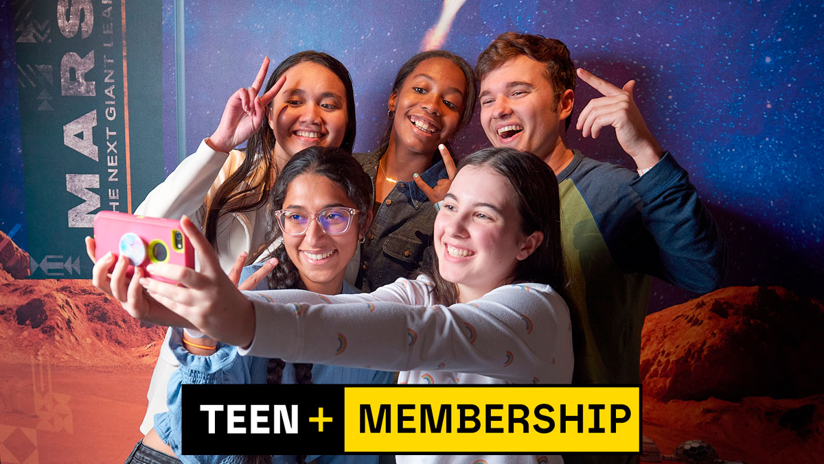 A group of teens takes a selfie in front of a colorful backdrop showcasing Mars, with the text "TEEN + MEMBERSHIP" prominently displayed