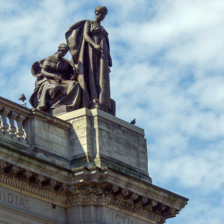 2 of the sculptures of Muses on the top of Carnegie Museum