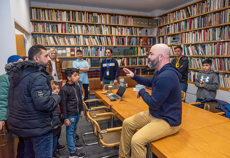 An Art museum instructor talking to a group of immigrant families.