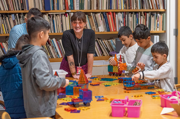 An Art museum instructor talking to a group of immigrant children.