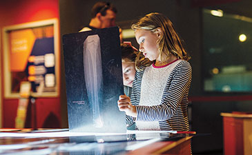 Two young girls looking at an xray at the Body Works exhibit at Carnegie Science Center