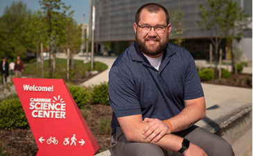 A portrait of Justin Tognarine in front of Carnegie Science Center