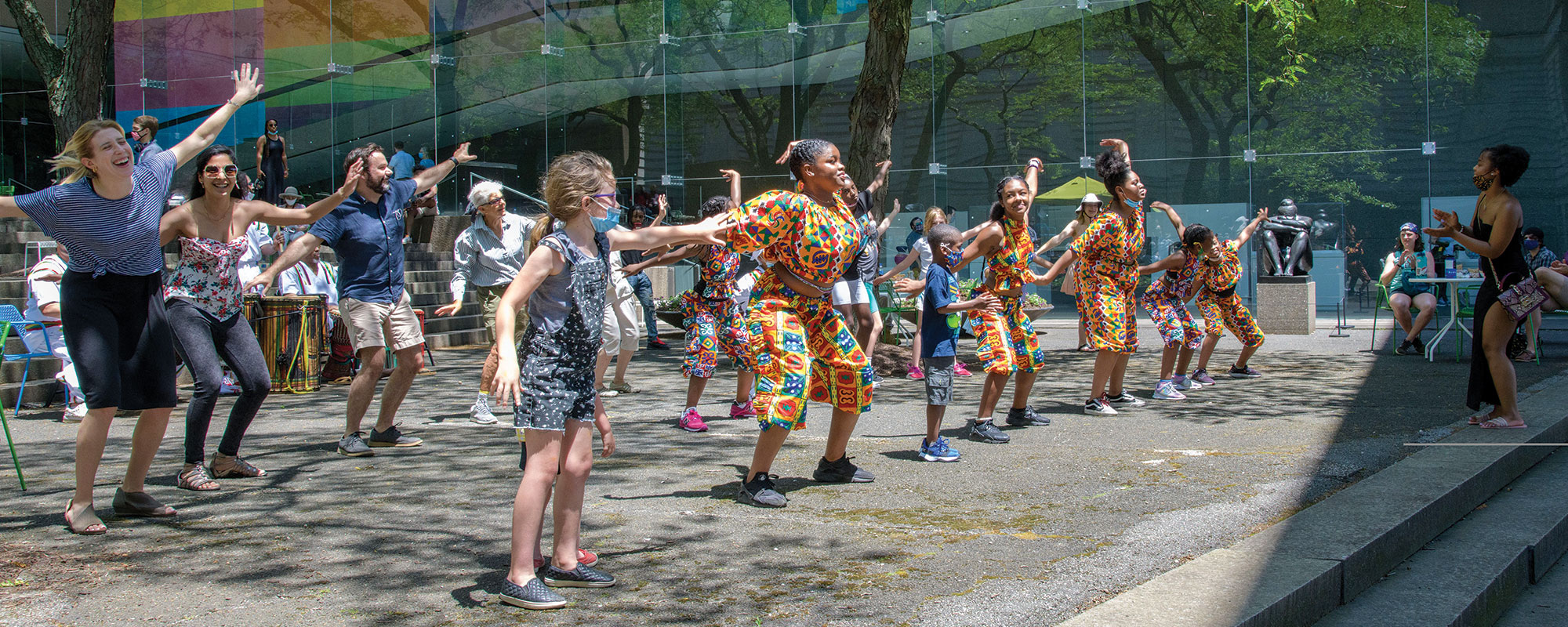 a group of dancers in the sculpture court of the museum.