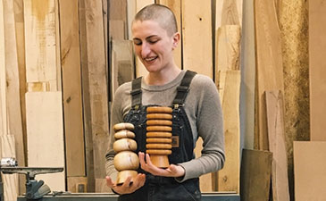Hanna Dausch holding some of her wood artwork pieces